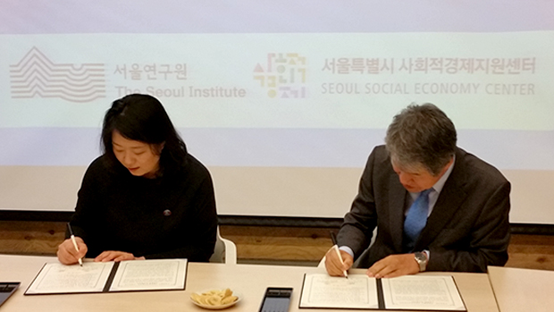 서울연구원장이 서울시 센터장과 나란히 앉아서 협약서에 서명을 하고 있습니다.