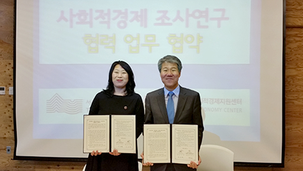 서울연구원장과 서울시 센터장이 협약서 서명후 협약서를 들고 웃으면서 서있습니다.