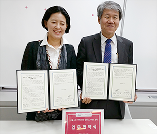 서울연구원과 서울시 NPO지원센터 대표가 협약서를 각각 들고 서서 웃고 있다